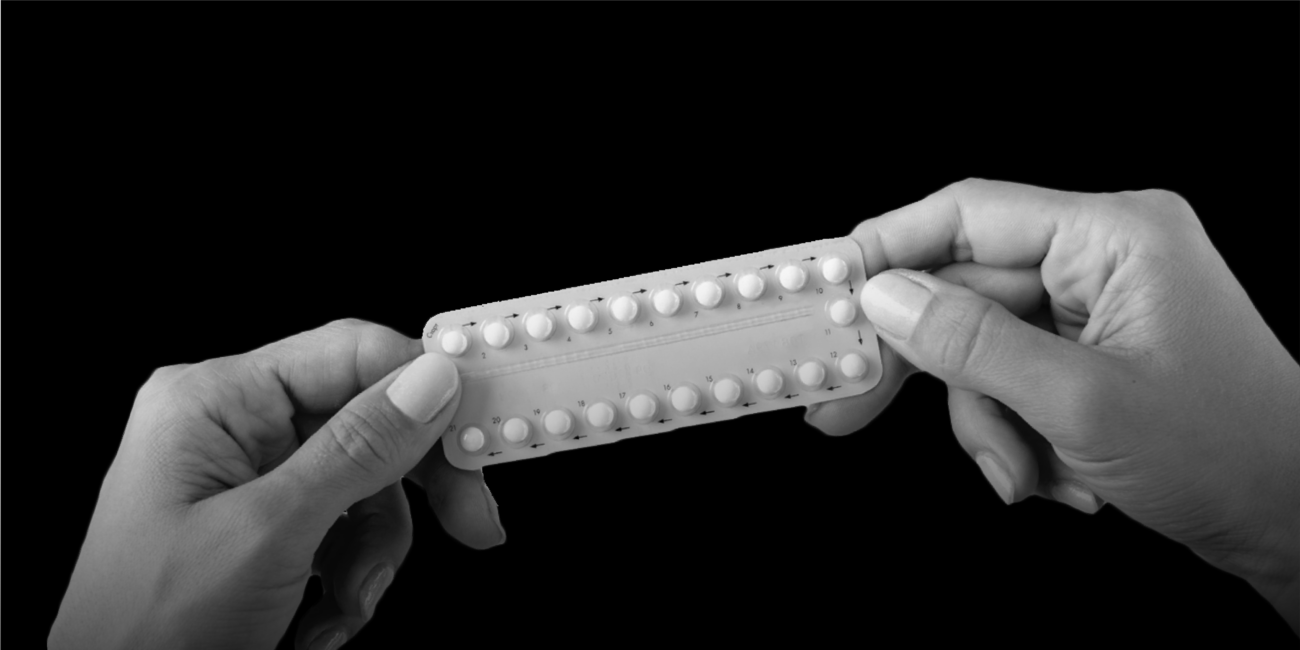 a person holding a complete blister pack of contraceptive pills