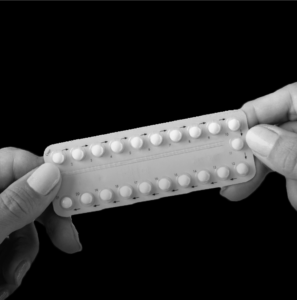 a person holding a complete blister pack of contraceptive pills