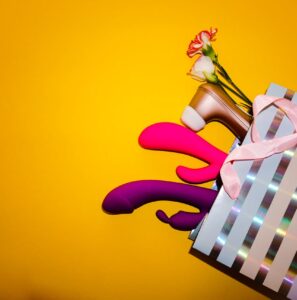A shopping bag with adult toys, flowers, and a high heel shoe on a vibrant yellow background.