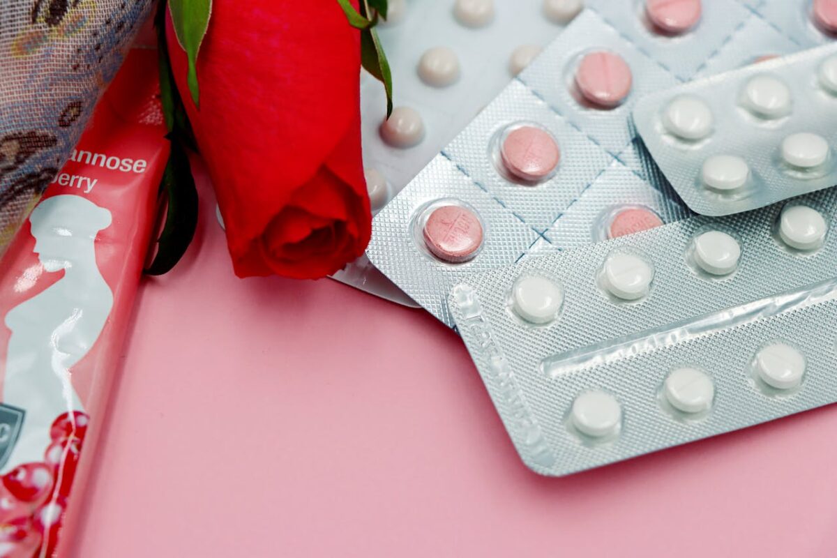 Emergency contraceptive pills in the Philippines - packs of birth control pills with a red rose on a pink background.