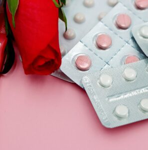 Emergency contraceptive pills in the Philippines - packs of birth control pills with a red rose on a pink background.