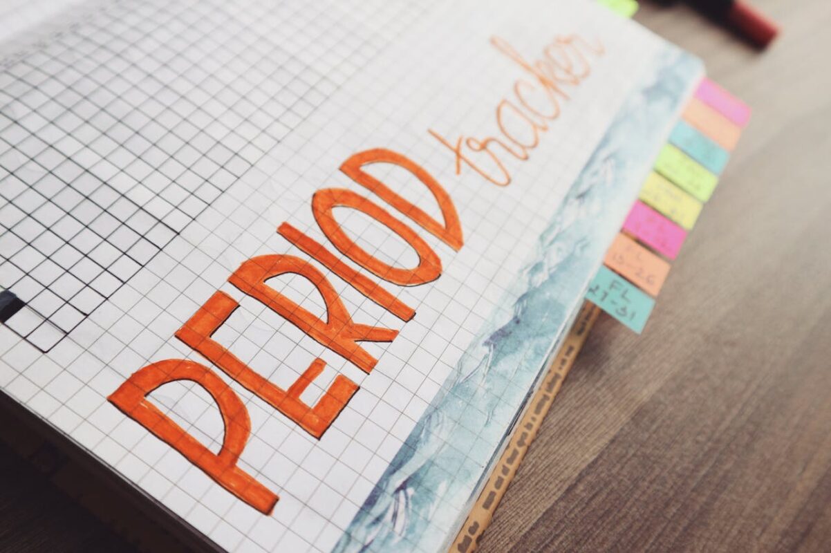 A close-up of a period tracker planner with colorful sticky notes.