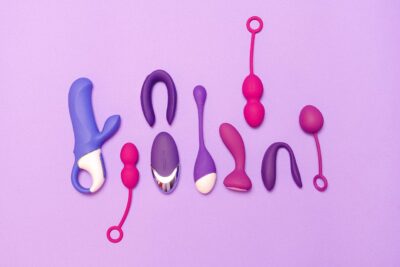 Assorted silicone female sex toys including vibrators and kegel balls arranged on a purple background