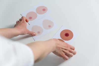 Hands sorting illustration cards showing diverse breast and nipple shapes for body awareness and health education