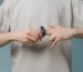 A man removing a cock ring from his finger, simulating a penis.