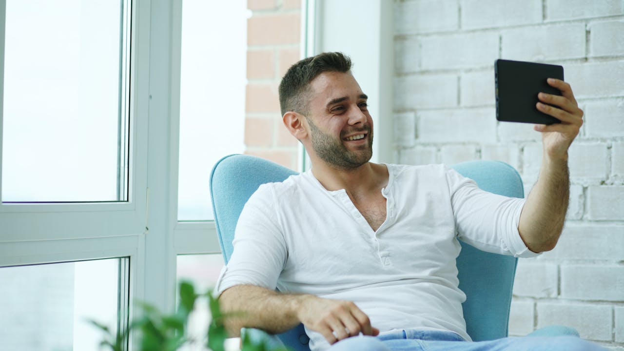A man smiling during a video call, a daily reality for those in a Philippines LDR. Staying connected is key to a healthy Filipino LDR.