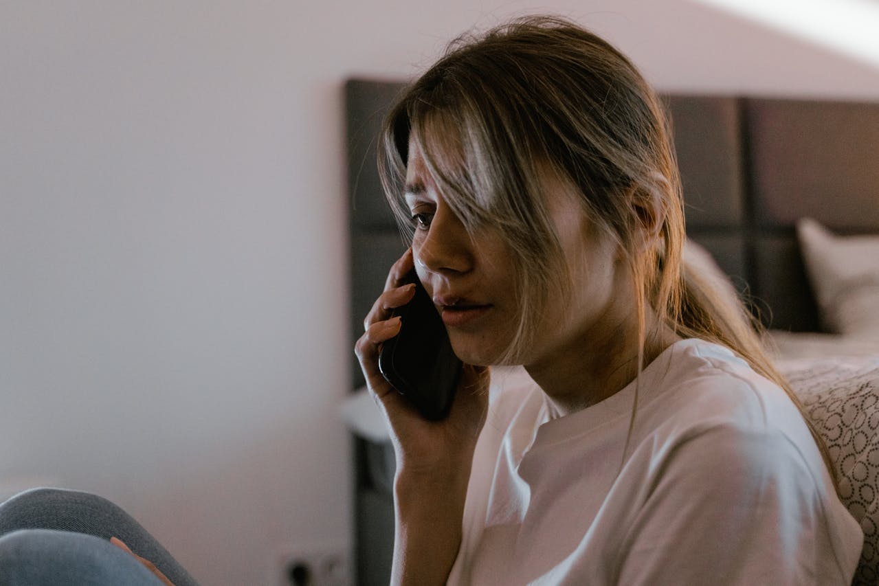 A woman looking emotional during a phone call. Navigating time zones and distance is a common challenge in a filipina ldr.