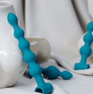 A lifestyle display of the best gay sex toys in the Philippines featuring teal ribbed beads placed elegantly alongside modern ceramic vases.