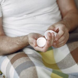 Man holding two supplement bottles at home, representing the growing use of male enhancement and male supplements in the Philippines today.