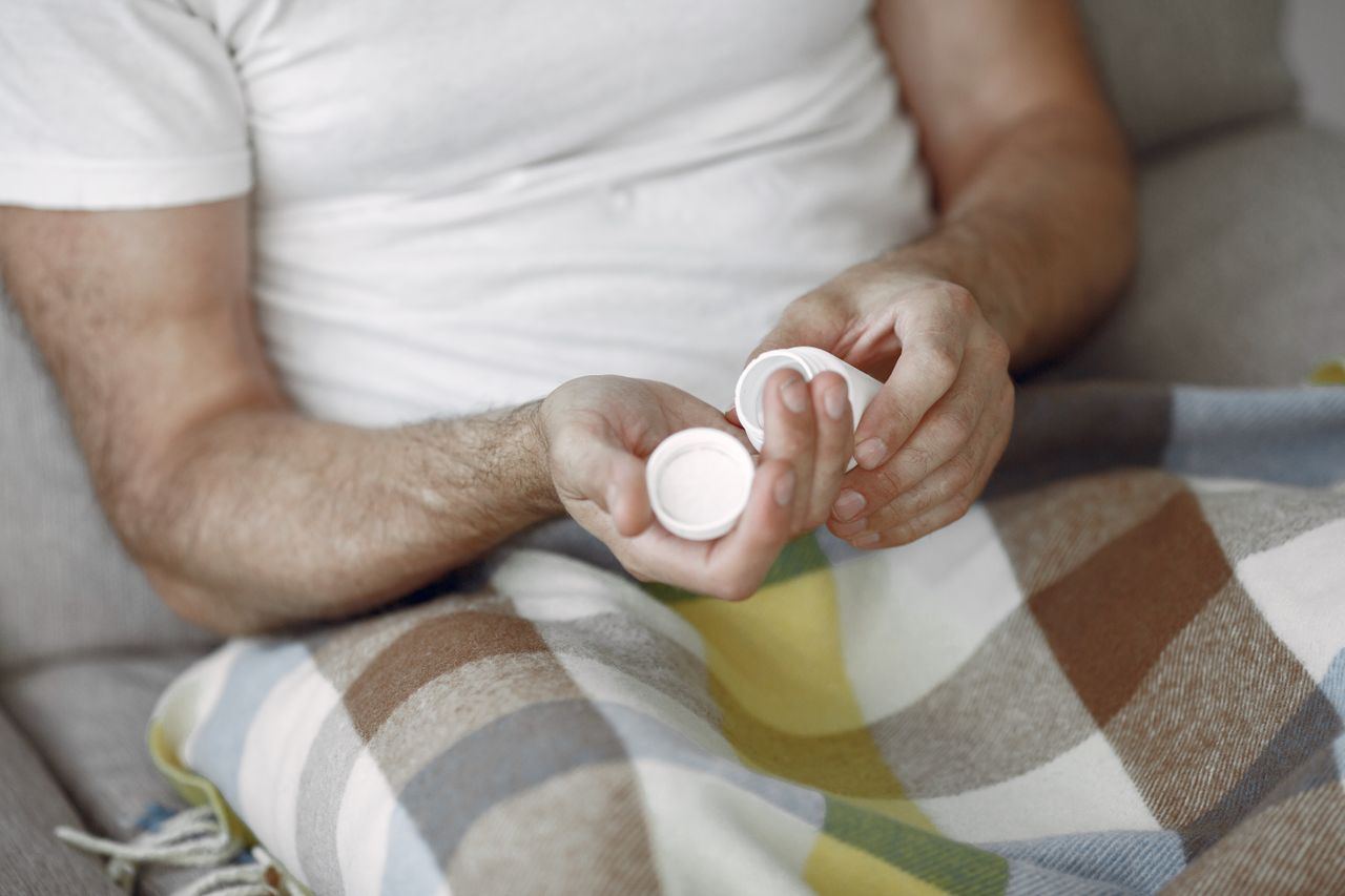 Man holding two supplement bottles at home, representing the growing use of male enhancement and male supplements in the Philippines today.