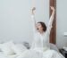 Woman stretching happily after waking up, symbolizing the confidence and energy that come from good intimate self care and daily wellness habits.