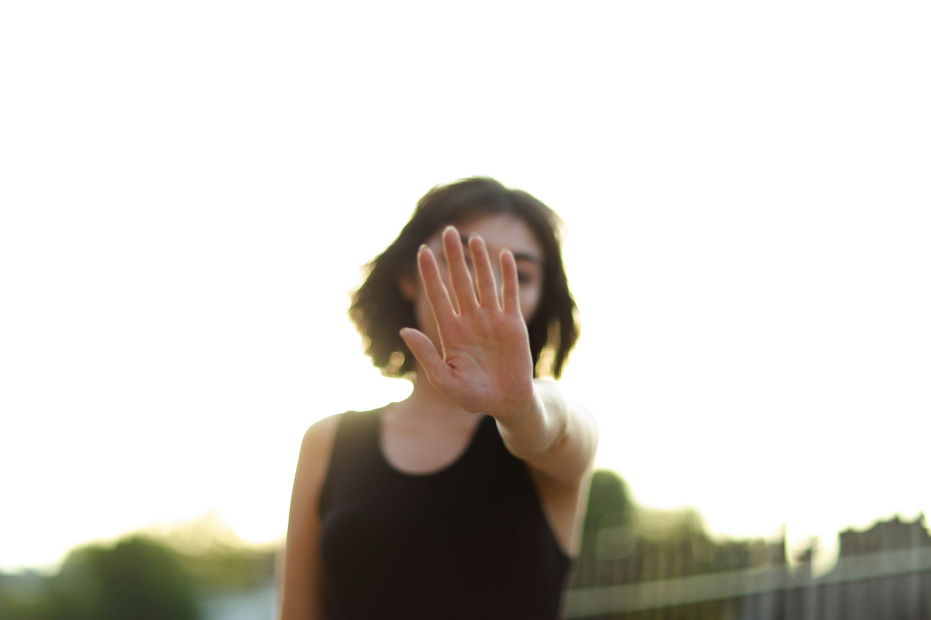 A woman holds her hand out in a stop gesture, symbolizing protection against harassment under the Safe Spaces Act or Bawal Bastos Law.