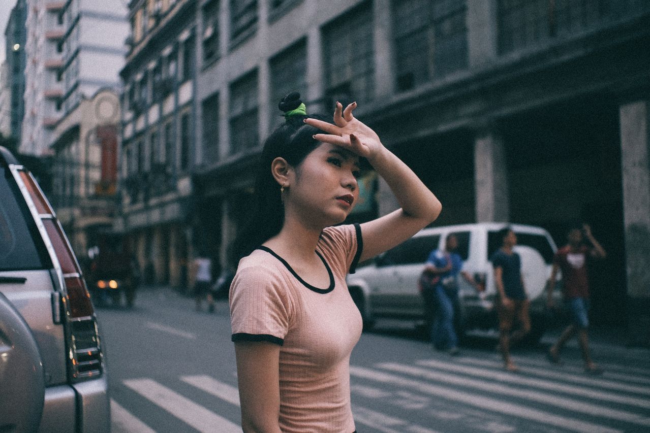 A woman walks across a busy Philippine street looking distressed, showing why the Bawal Bastos Law and Safe Spaces Act are vital.